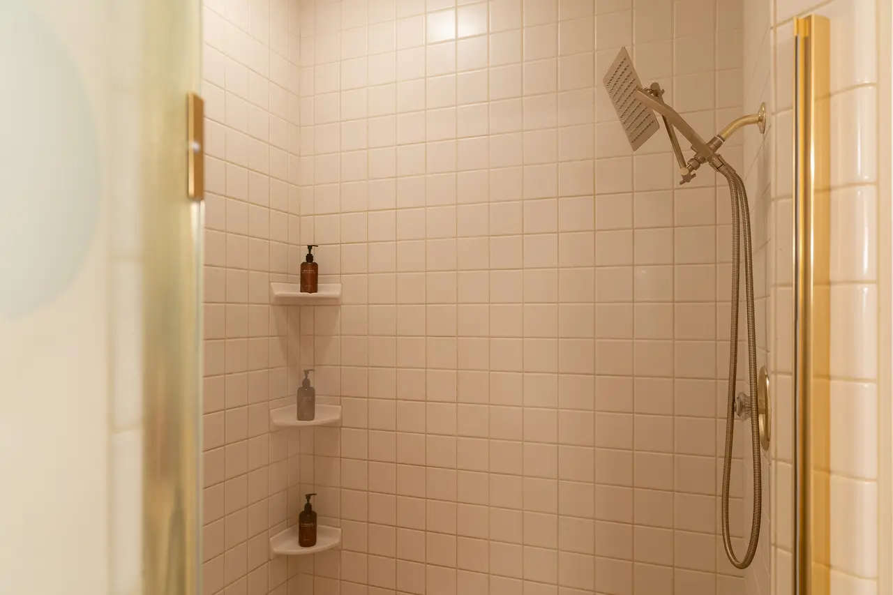 The spacious walk-in shower for two features dual rainfall showerheads and floor-to-ceiling custom tile. 