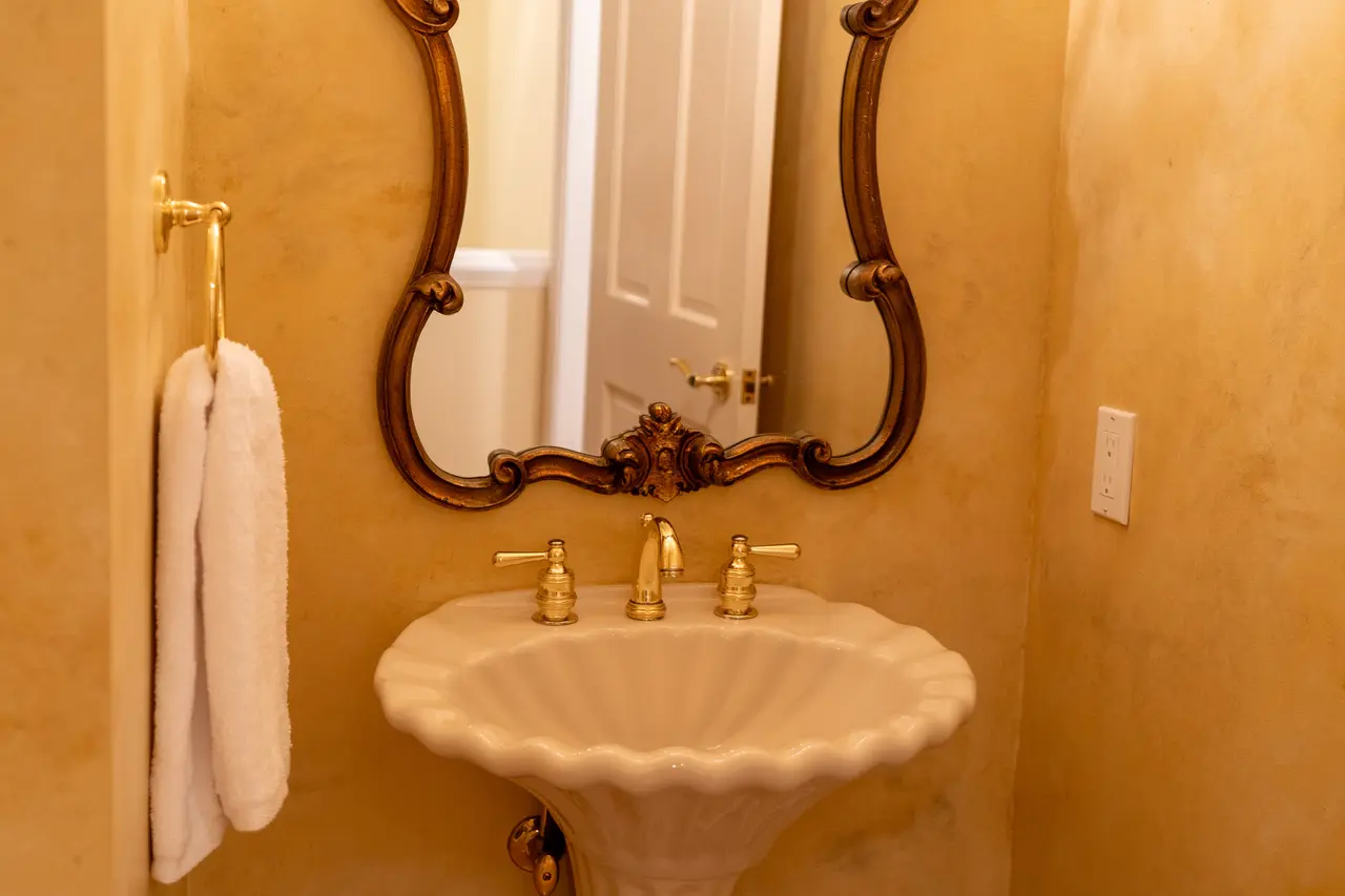 An elegant, Victorian-style powder room is conveniently located on the main floor, just off the main living area, for guests.