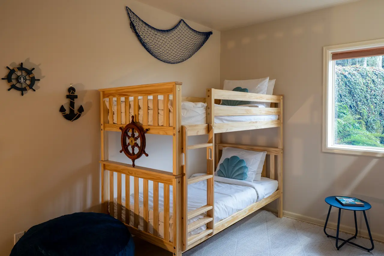 A charming and versatile coastal sleeping quarter featuring sturdy solid-wood frames and premium mattresses, ensuring a comfortable night's rest for guests of any age