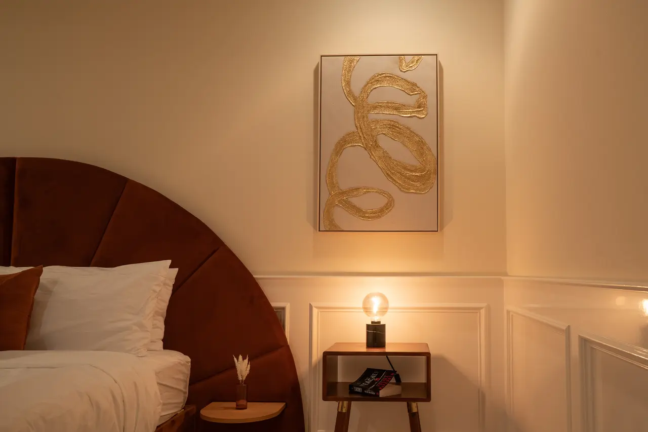 Warm, designer lighting and curated gold-leaf art create a sophisticated and restful ambiance.