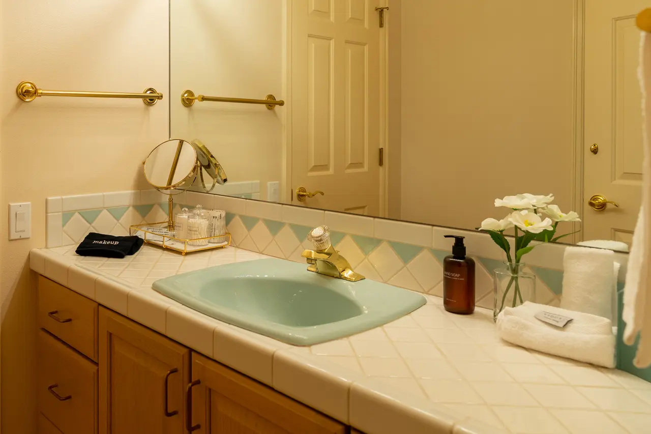 This bright and spacious full guest bathroom serves the Twin and the King suites, featuring a large, clean vanity and a full tub/shower combo.